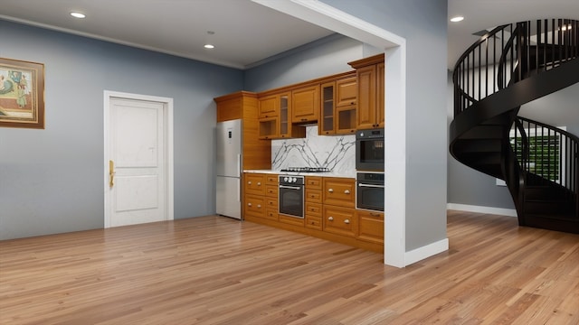 kitchen featuring tasteful backsplash, ornamental molding, white fridge, light hardwood / wood-style floors, and stainless steel gas stovetop