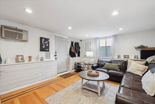 living area featuring an AC wall unit, recessed lighting, and wood finished floors