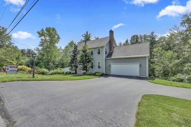 42 Mcgregory Rd, Sturbridge, MA 01566 - colonial house with asphalt driveway, a front lawn, a garage, and a chimney