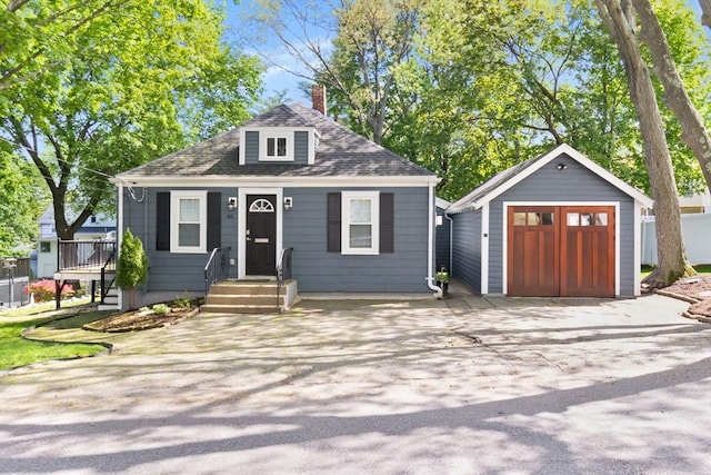 46 Leonard St, Woburn, MA 01801 - view of front of house with a garage, an outdoor structure, a chimney, and roof with shingles