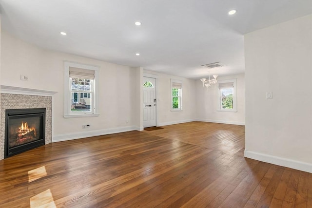 46 Leonard St, Woburn, MA 01801 - unfurnished living room with wood-type flooring, a chandelier, baseboards, a glass covered fireplace, and recessed lighting