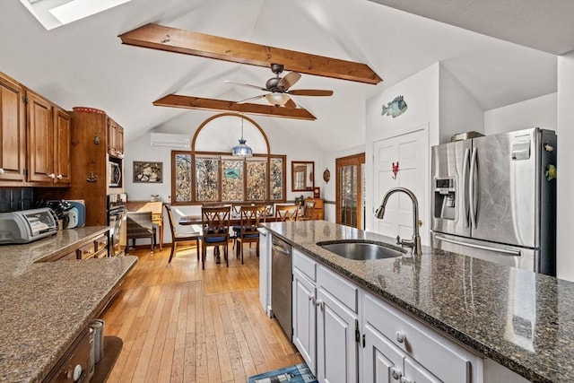 125 Wamsutta Rd, Eastham, MA 02642 - kitchen featuring appliances with stainless steel finishes, a sink, light wood-style floors, a ceiling fan, and dark stone counters