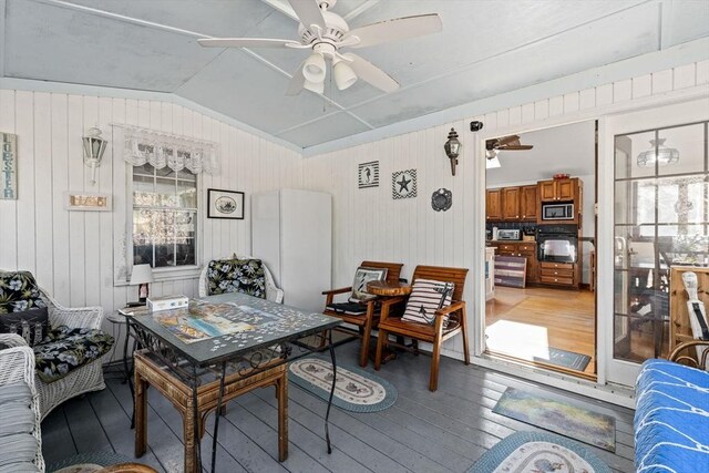 125 Wamsutta Rd, Eastham, MA 02642 - dining area with light wood-type flooring, ceiling fan, lofted ceiling, and wooden walls
