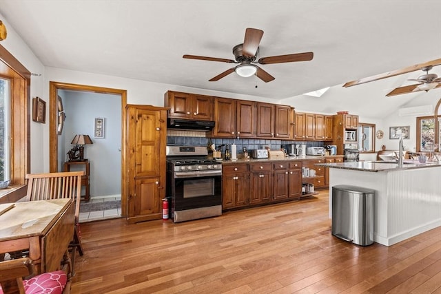 125 Wamsutta Rd, Eastham, MA 02642 - kitchen featuring appliances with stainless steel finishes, ceiling fan, under cabinet range hood, light wood-style floors, and decorative backsplash