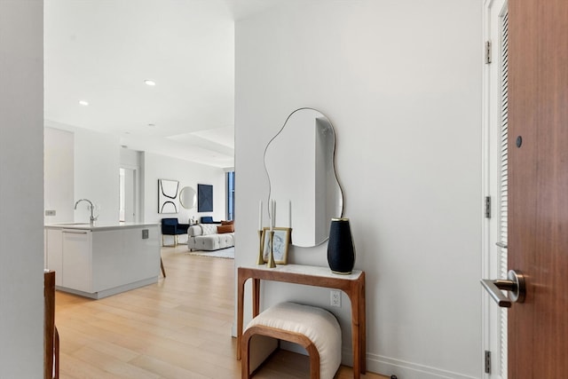 corridor with sink and light hardwood / wood-style floors