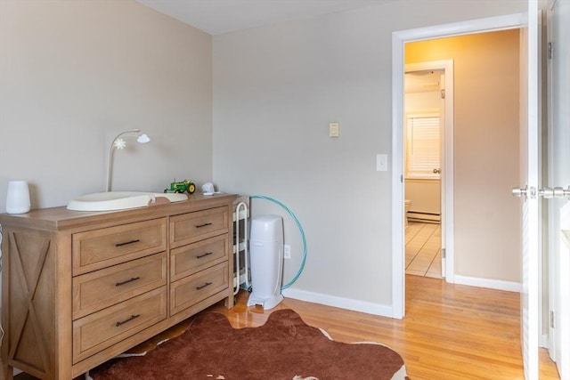 interior space featuring baseboard heating, sink, and light hardwood / wood-style floors