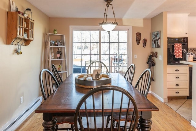 dining space featuring baseboard heating and light hardwood / wood-style flooring