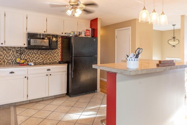 kitchen featuring white cabinetry, black appliances, light tile patterned floors, pendant lighting, and backsplash