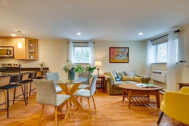 dining room featuring baseboard heating, a healthy amount of sunlight, and light wood-type flooring