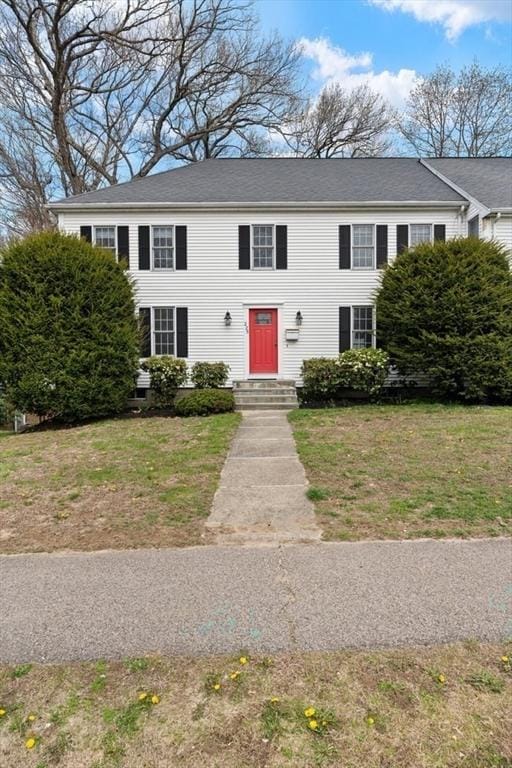 colonial home featuring a front lawn