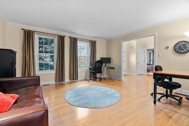 living room featuring baseboards, ornamental molding, and wood finished floors