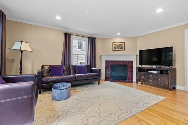 living room featuring recessed lighting, ornamental molding, wood finished floors, and a fireplace
