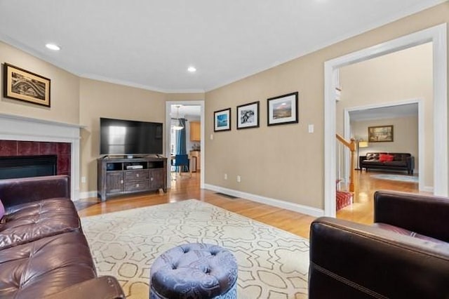 living area with recessed lighting, baseboards, wood finished floors, and a fireplace