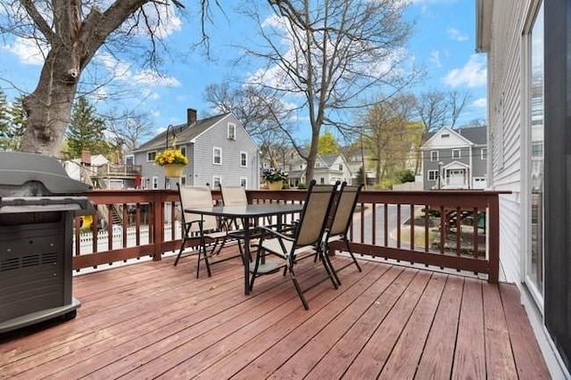 wooden terrace featuring a residential view and outdoor dining area