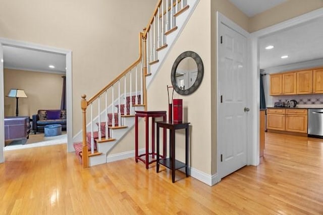 stairway featuring recessed lighting, baseboards, and wood finished floors