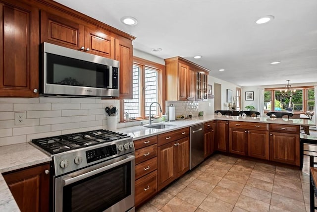 37 Berkeley Dr, Falmouth, MA 02536 - kitchen with appliances with stainless steel finishes, decorative backsplash, a peninsula, recessed lighting, and light stone counters