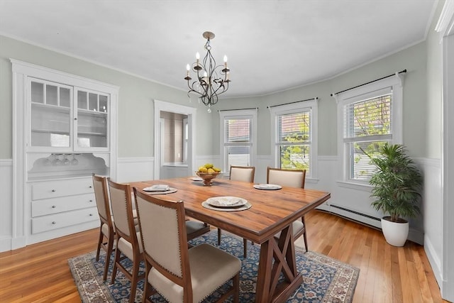 708 Belmont St Unit 708, Watertown, MA 02472 - dining space with baseboard heating, wainscoting, light wood finished floors, and a chandelier