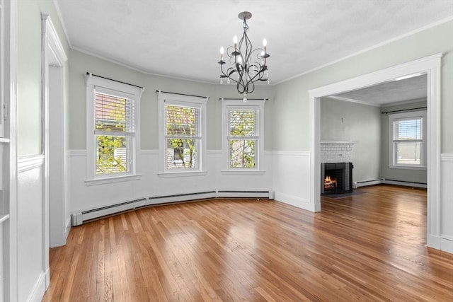 708 Belmont St Unit 708, Watertown, MA 02472 - unfurnished dining area featuring an inviting chandelier, ornamental molding, hardwood / wood-style flooring, and a fireplace