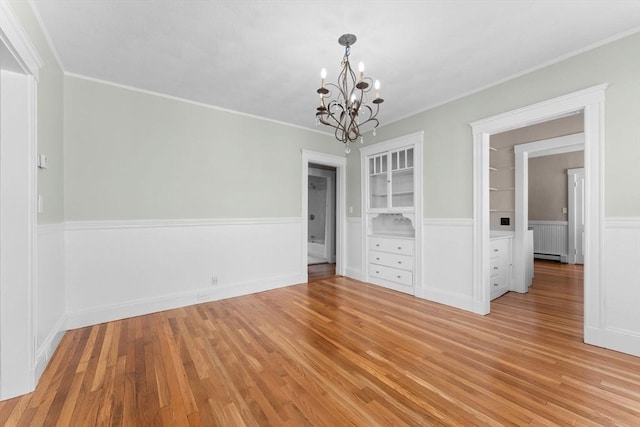 708 Belmont St Unit 708, Watertown, MA 02472 - unfurnished dining area featuring an inviting chandelier, radiator, ornamental molding, and light wood-style floors