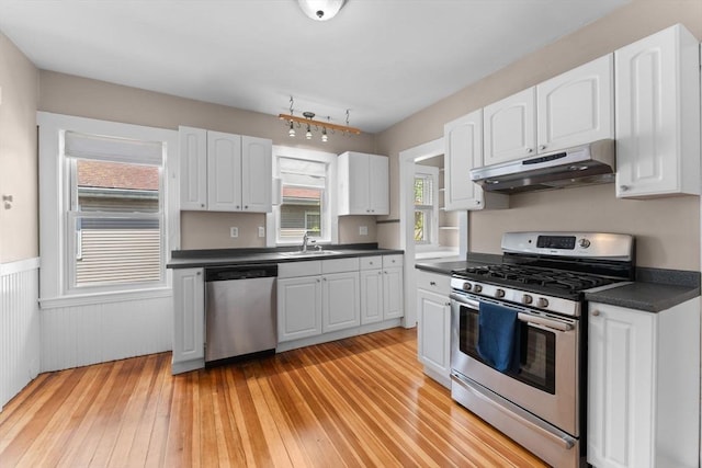 708 Belmont St Unit 708, Watertown, MA 02472 - kitchen with dark countertops, a sink, white cabinets, under cabinet range hood, and stainless steel appliances