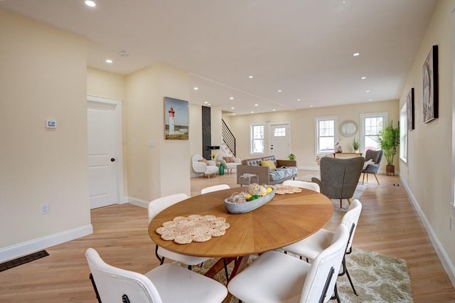 dining room with stairway, recessed lighting, light wood-style floors, and baseboards