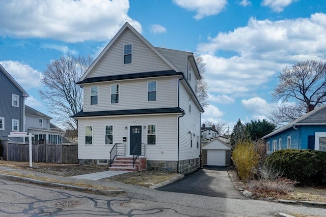 view of front of property with a garage, an outbuilding, driveway, and fence