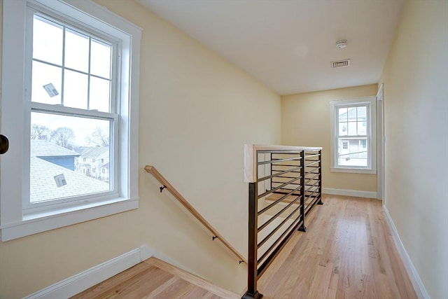 stairs with visible vents, baseboards, wood finished floors, and a baseboard radiator