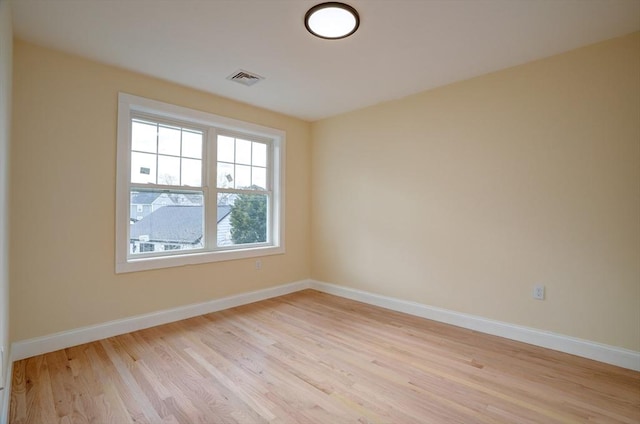 unfurnished room with visible vents, light wood-style floors, and baseboards