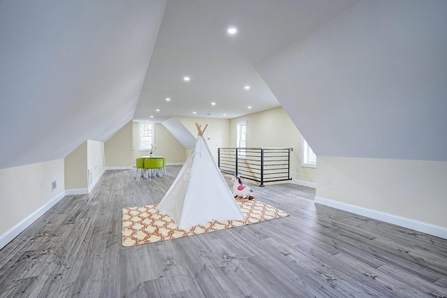 rec room featuring lofted ceiling, plenty of natural light, wood finished floors, recessed lighting, and baseboards