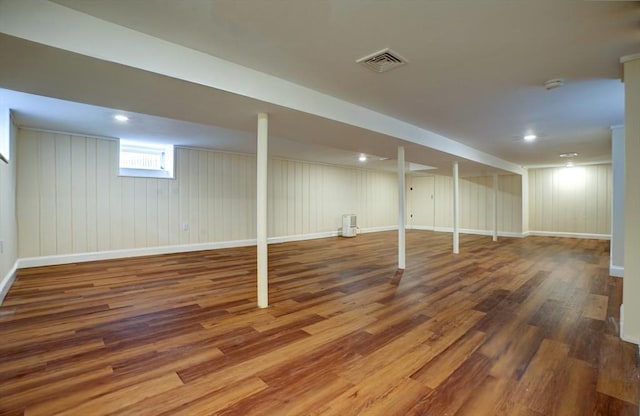 basement with visible vents, baseboards, and wood finished floors