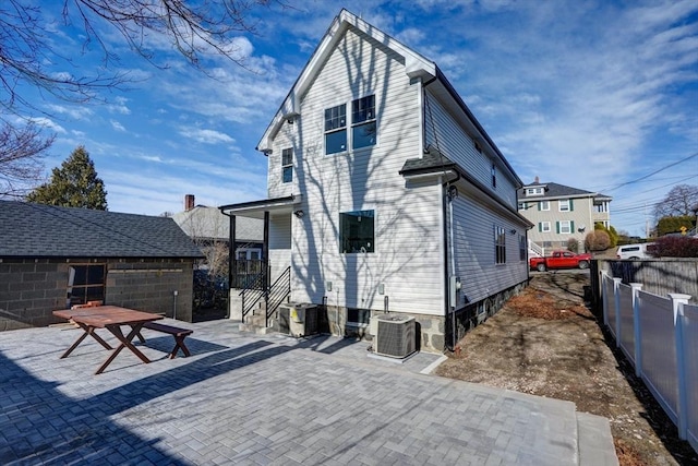 rear view of house featuring cooling unit, a patio area, and fence