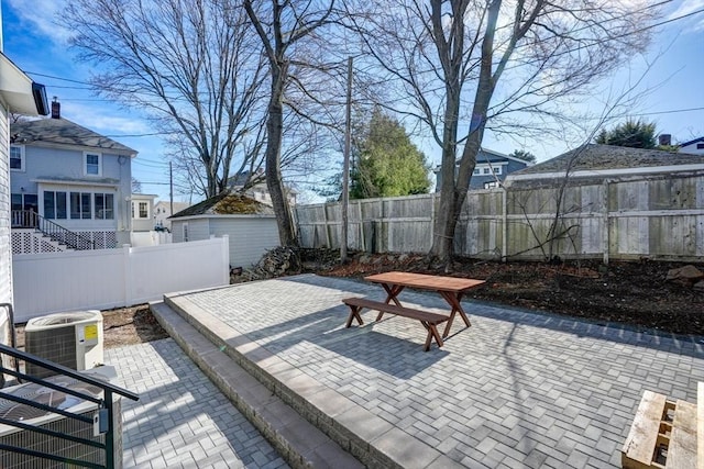 view of patio / terrace with an outdoor structure, central air condition unit, and a fenced backyard