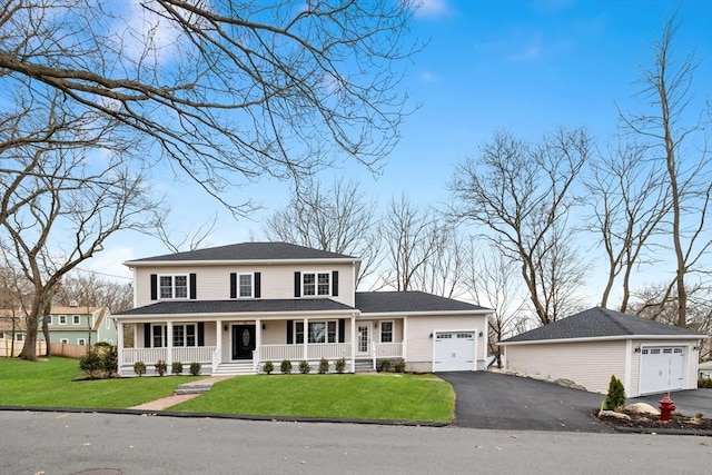view of front of home featuring covered porch, a garage, a front lawn, and driveway