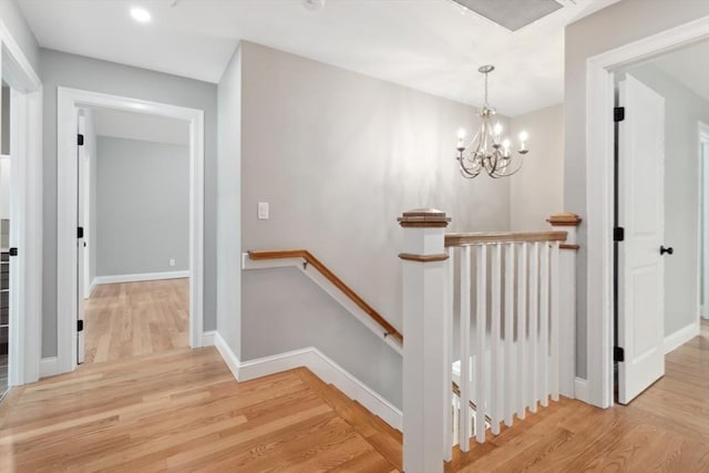stairs with wood finished floors, a chandelier, baseboards, and recessed lighting