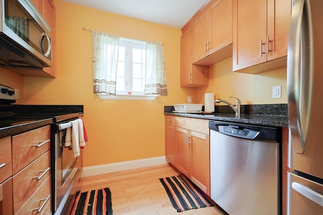 6 Janet Rd Unit 10, Easton, MA 02375 - kitchen with appliances with stainless steel finishes, a sink, baseboards, light wood-type flooring, and dark stone counters