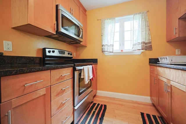 6 Janet Rd Unit 10, Easton, MA 02375 - kitchen with appliances with stainless steel finishes, light wood finished floors, baseboards, and dark stone counters