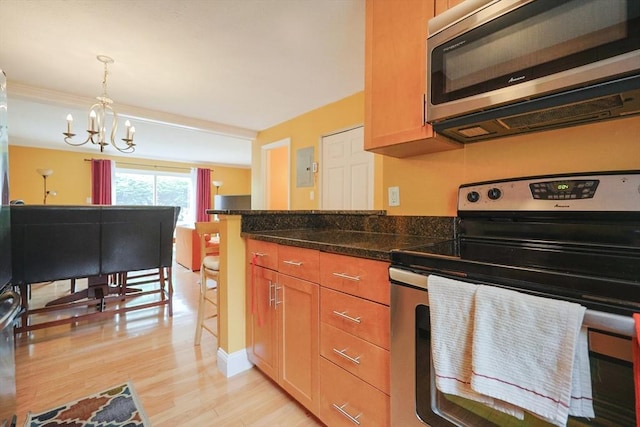 6 Janet Rd Unit 10, Easton, MA 02375 - kitchen featuring stainless steel appliances, light wood finished floors, a chandelier, hanging light fixtures, and dark stone counters