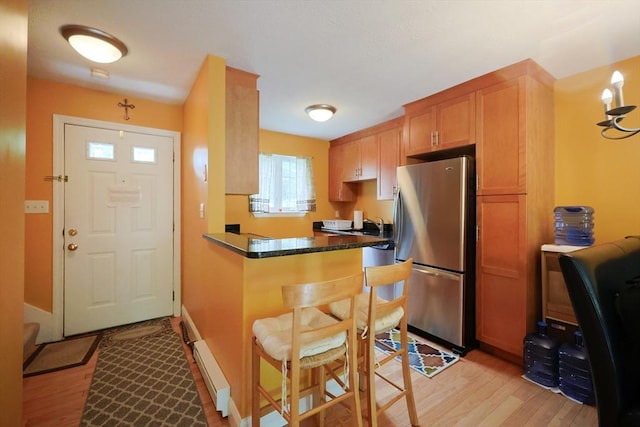 6 Janet Rd Unit 10, Easton, MA 02375 - kitchen featuring freestanding refrigerator, light wood-style flooring, a kitchen breakfast bar, and a peninsula
