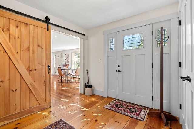 foyer featuring light wood-style floors and a barn door