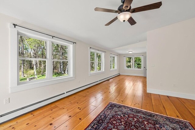 spare room with ceiling fan, wood-type flooring, baseboards, a baseboard radiator, and vaulted ceiling