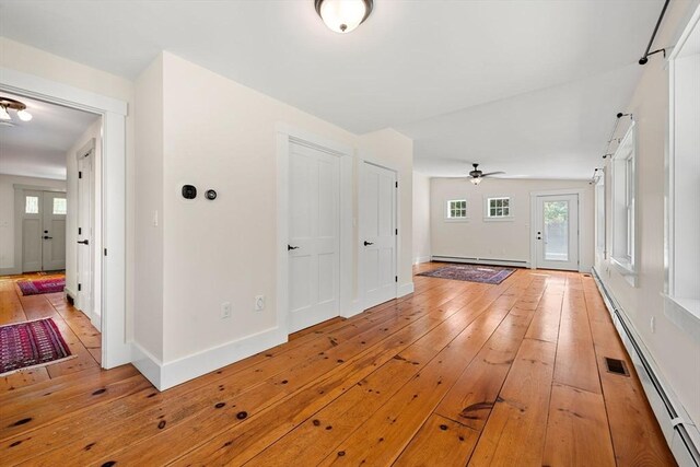entryway featuring plenty of natural light, light wood finished floors, ceiling fan, and baseboard heating