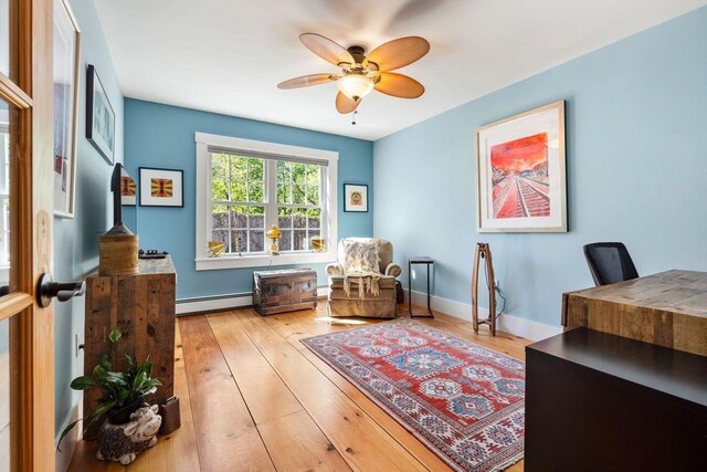 office space with baseboards, a baseboard radiator, ceiling fan, and hardwood / wood-style floors