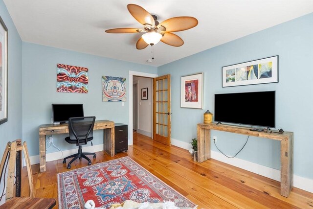 office space featuring baseboards, ceiling fan, and wood finished floors