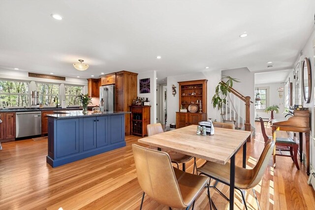 dining space featuring light wood-type flooring, recessed lighting, and stairs