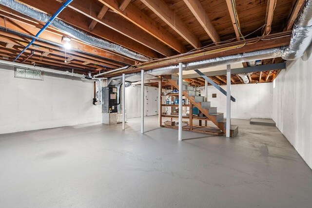 unfinished basement with stairs and heating unit