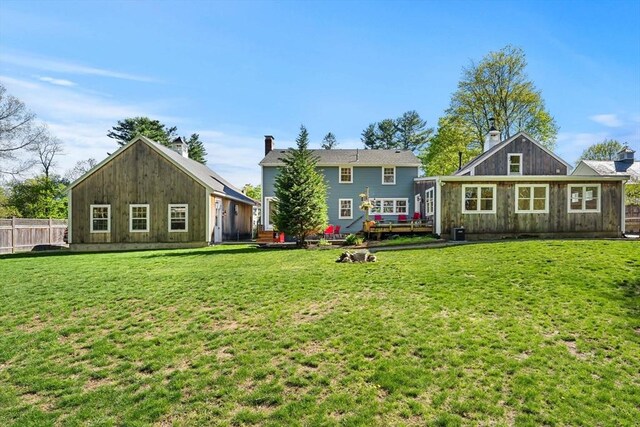 back of house with fence, a yard, and a deck