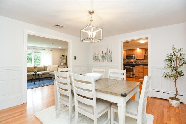 23 Green Lodge St, Canton, MA 02021 - dining area featuring a baseboard radiator, light wood-type flooring, a chandelier, and a wainscoted wall