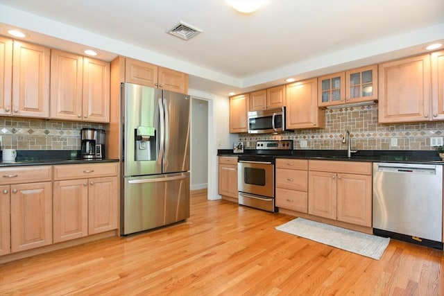 23 Green Lodge St, Canton, MA 02021 - kitchen featuring appliances with stainless steel finishes, a sink, light brown cabinets, backsplash, and light wood-style floors