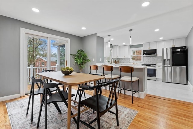 dining room with light wood finished floors and recessed lighting