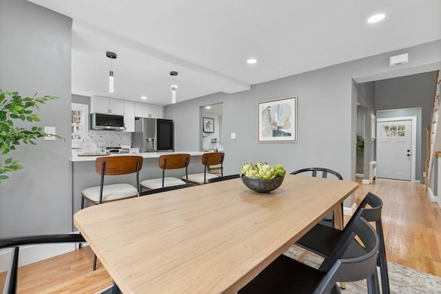 dining area with light wood-style floors, recessed lighting, and baseboards